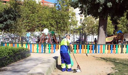 Un barrendero limpia, en 2014, en el parque del Casino de la Reina, en Lavapiés.