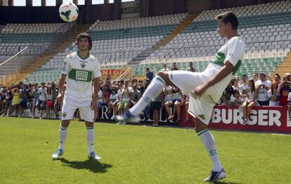 Manu del Moral y Miroslav Stevanovic, los nuevos fichajes del Elche, dando unos toques durante su presentación en el estadio Martínez Valero. Ambos llegan cedidos desde el Sevilla, al que no podrán enfrentarse. Del Moral, delantero de 29 años, llega "tras un año difícil" en el que tan solo marcó un gol en los siete partidos que disputó. Stevanovic, centrocampista de 22 años, ha manifestado su ilusión de jugar el Mundial 2014 con Bosnia-Herzegovina, selección con la que es internacional.