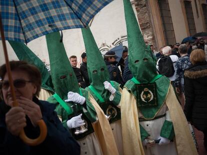 Una mujer se protege de la lluvia durante una procesión en Málaga el año pasado.