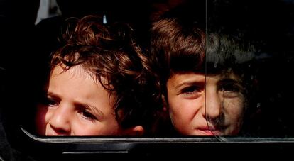 Dos niños sirios llegan en autobús al campo de refugiados de la Media Luna Roja instalado en Altinozu, a 30 kilómetros de la frontera entre Siria y Turquía.