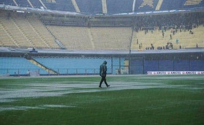 Un hombre camina bajo la lluvia dentro de la Bombonera inundada, antes de que la Conmebol suspenda la final entre Boca y River por la Libertadores.