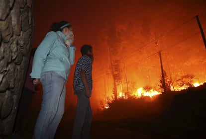  Vecinos observan las llamas del incendio forestal declarado en la parroquia en Oia (Pontevedra). La situación es muy complicada, según fuentes de las brigadas de extinción, ya que el fuego está dividido en dos frentes.