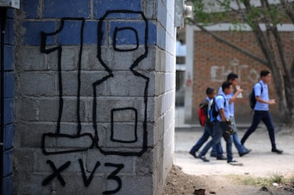 Cuatro alumnos del Instituto Saúl Zelaya de Tegucigalpa caminan por los alrededores del centro, que está bajo el control de la pandilla juvenil Mara 18, en abril de 2016.
