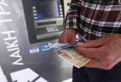 Un hombre saca dinero de un cajero automático. EFE/Archivo
