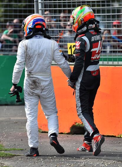 Fernando Alonso (izquierda) y Esteban Gutiérrez hablan tras comprobar que han salido ilesos del choque.