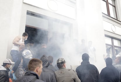 Los manifestantes rompieron los cristales y lanzaron bombas de humo y petardos contra el edificio en Lugansk (Ucrania), 29 de abril de 2014.