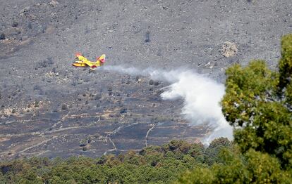Un avión apaga incendios de la Unidad Militar de Emergencias (UME) vierte agua  sobre el incendio forestal originado en el término municipal de Robledo de Chavela (Madrid).