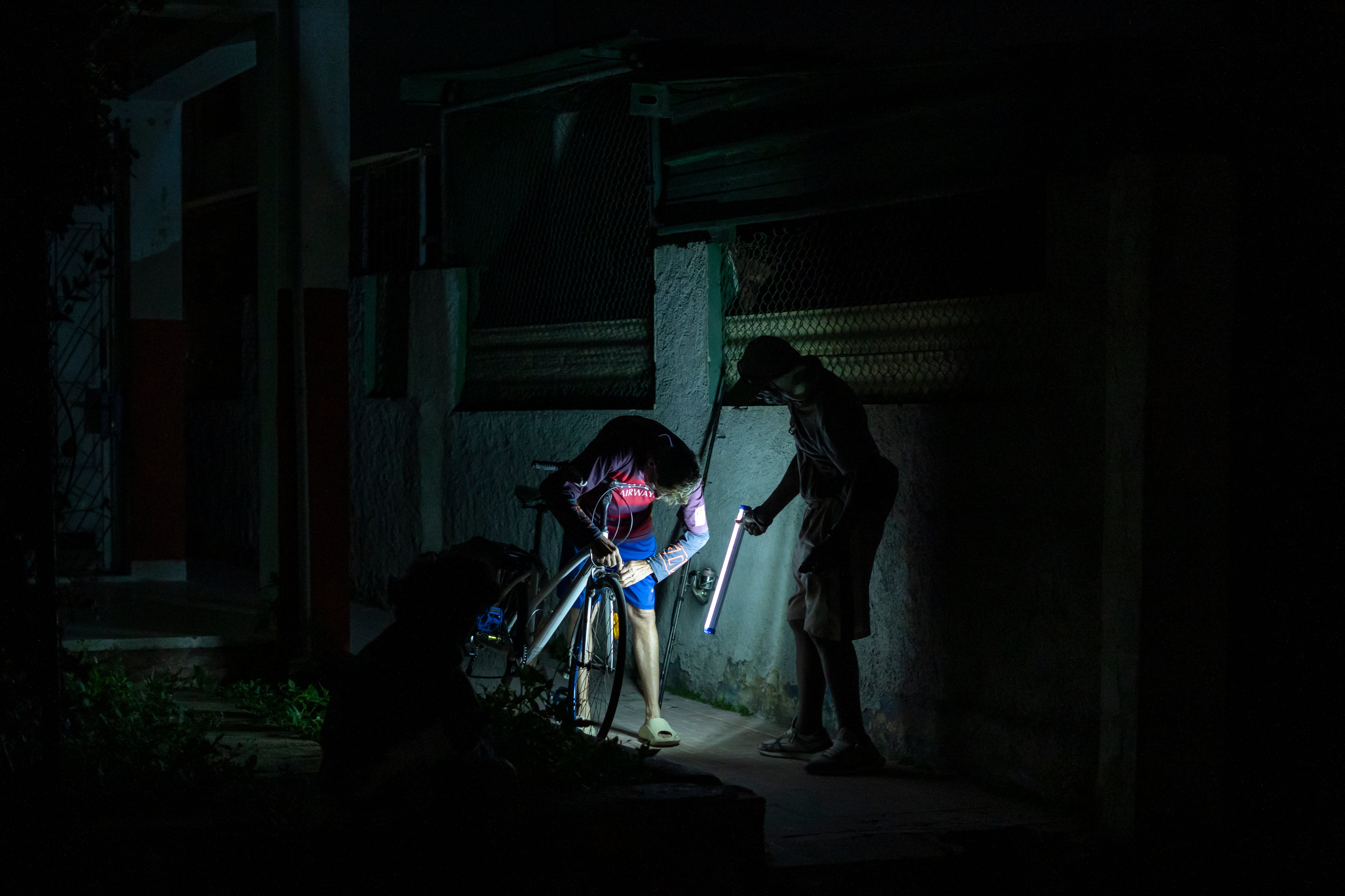 Dos personas se iluminan durante el apagón nacional del 21 de marzo en La Habana.