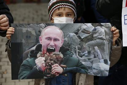 Un niño surcoreano sostiene un cartel que representa al presidente ruso, Vladímir Putin, como si fuera un vampiro, durante una protesta de musulmanes residentes en Corea del Sur contra la política del Gobierno Ruso en Siria, en Séul (Corea del Sur), el 19 de diciembre de 2016.