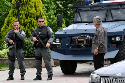 Policías kosovares que custodian el edificio municipal de Leposavic, localidad de la zona mayoritariamente serbia, hablan con un vecino, este sábado.