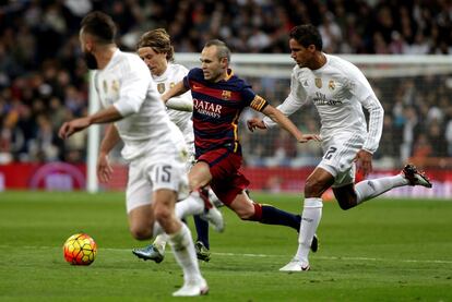 Iniesta entre tres contrarios durante el encuentro entre el Real Madrid y el Barcelona.