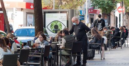 Imagen de una terraza madrileña en la era Covid: algunas mascarillas y distancia de seguridad entre las mesas.