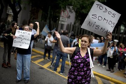 Tras ocho años de investigaciones, Alberto Nisman denunció el pasado miércoles a Fernández por considerar que el memorándum de entendimiento aprobado en enero de 2013 con Irán incluía un presunto encubrimiento de los sospechosos del atentado contra la AMIA a cambio de las relaciones comerciales e intercambio de petróleo. En la imagen, un grupo de personas protesta en los alrededores del Congreso en Buenos Aires.