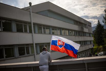 Un hombre ondeaba una bandera de Eslovaquia en el hospital en el que está ingresado Robert Fico, este jueves en Banska Bystrica.