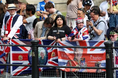 Varios espectadores esperan a los miembros de la familia real británica desfilar en el Trooping the Colour. En el desfile participan también más de 1.400 soldados, 200 caballos y 400 músicos en un gran despliegue de precisión militar, equitación y fanfarria.