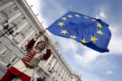 Un miembro del grupo italiano &quot;Sbandieratori di Siena&quot; mientras sostiene una bandera de la Uni&oacute;n Europea  frente al Palacio Real en Madrid.