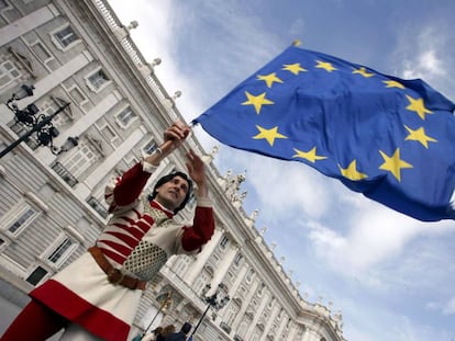 Um membro do grupo italiano "Sbandieratori dei Siena" enquanto sustenta uma bandeira da União Europeia  em frente ao Palácio Real em Madri.