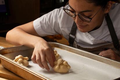 Una joven cocinera prepara pan de muerto, en Ciudad de México.