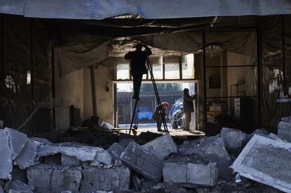 Un home intenta reparar un edifici danyat a Donetsk, el 14 de febrer.