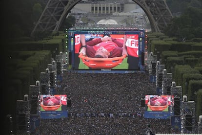 La gente ve en una pantalla gigante en los Campos de Marte, la salida de Cristiano en una camilla después de su lesión.