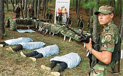 Un soldado colombiano en una base de Medellín, junto a los cadáveres de cuatro rebeldes abatidos.