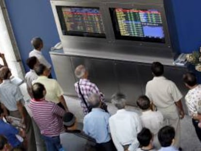 Un grupo de inversores observa unos monitores en los que se muestran los valores de la Bolsa de Singapur. EFE/Archivo