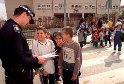 Un policía municipal de Fuenlabrada vigila la entrada y la salida de alumnos del colegio Velázquez.