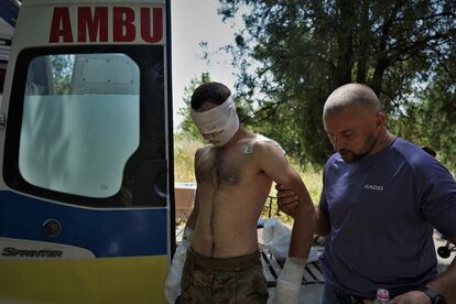 Un militar con quemaduras es ayudado tras ser atendido para llegar a la ambulancia que le llevará a un hospital de Zaporiyia. 