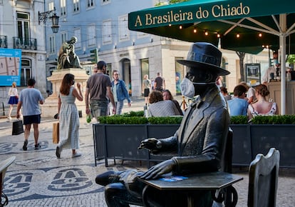 Una escultura de Pessoa a Lisboa, cubierta con una mascarilla.