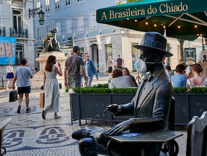 Una escultura de Pessoa a Lisboa, cubierta con una mascarilla.