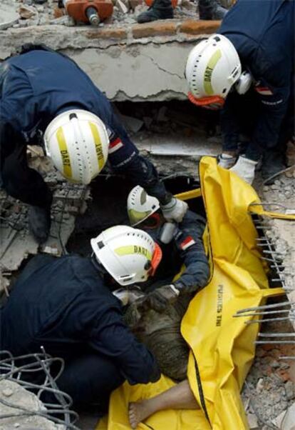 Bomberos de Singapur recuperan un cadáver, ayer en Gunungsitoli.