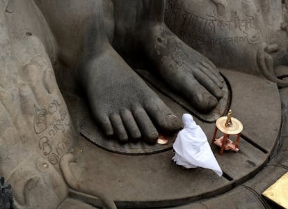 Una mujer reza ante la estatua del gran maestro Bahubali con motivo de celebración del Mahamastakabhisheka, evento que se celebra cada 12 años, en Shravanabelagola (India).