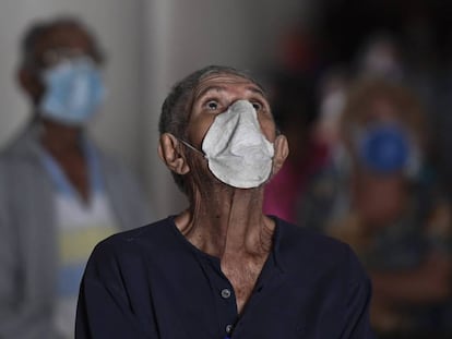 Un hombre con mascarilla reza en una iglesia de Caracas, en Venezuela.