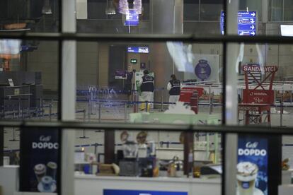 Vista de l’interior de l’aeroport, amb la policia recollint proves de l’explosió.