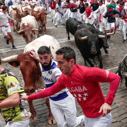 Varios mozos corren delante de la manada de Victoriano del Río en el tercer encierro de los Sanfermines este martes, en Pamplona.