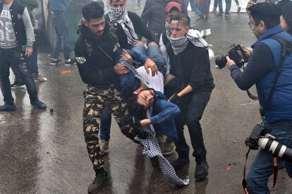 Un grupo de manifestantes llevan a un hombre desmayado después de inhalar gas lacrimógeno.