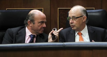 El ministro de Economía y Competitividad, Luis de Guindos, y el ministro de Hacienda, Cristóbal Montoro, durante el pleno extraordinario del Congreso sobre la Ley de Estabilidad Presupuestaria.