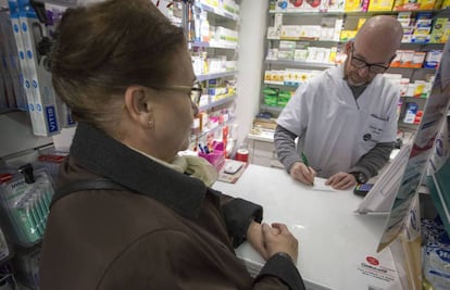 Una mujer compra un medicamento en una farmacia en Madrid.