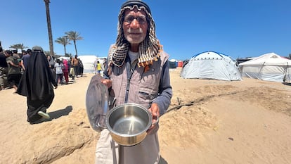 Ahmed al Najjar zeigt einen leeren Topf. Er hat für Essen angestanden, es aber nicht bekommen.