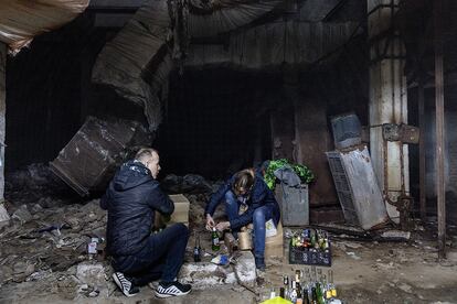 Dos personas fabrican cócteles molotov en el sótano de un refugio antiaéreo en Kiev, este sábado. El Ministerio de Defensa ucranio llamó a la población a resistir. "Pedimos a los ciudadanos que nos informen de los movimientos de tropas, que fabriquen cócteles Molotov y neutralicen al enemigo".