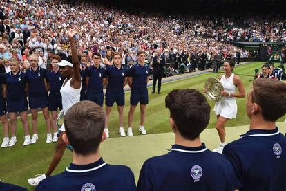 Venus Williams y Garbiñe Muguruza en la pista de Wimbledon tras recibir sus trofeos.