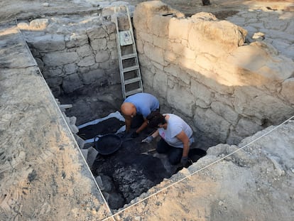 Dos arqueólogos excavan una habitación subterránea del edificio romano de Nueva Carteya.