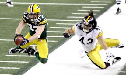 , de Green Bay, trata de eludir el marcaje de Polamalu.