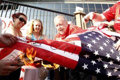 Aficionados del Liverpool queman una bandera estadounidense en los exteriores de Anfield Road en protesta por la marcha de Rafa Benítez.