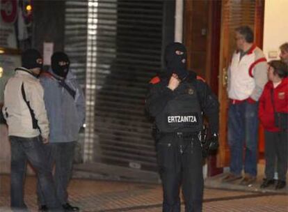 Varios <i>ertzainas</i> y vecinos de San Sebastián, cerca del lugar donde anoche estallaron dos bombas.