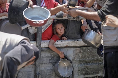 Una niña espera con una olla vacía el reparto de comida por parte de una organización benéfica en el barrio de Rimal, Ciudad de Gaza, el viernes 25 de julio.