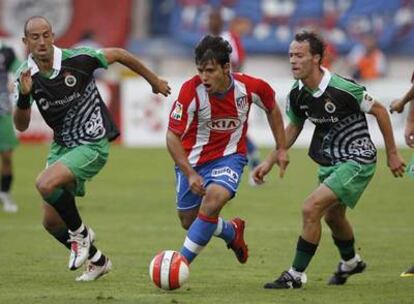 Agüero avanza con el balón seguido por Colsa y Pinillos.