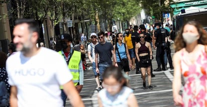 Varias personas pasean con y sin mascarilla, en el centro de Madrid.