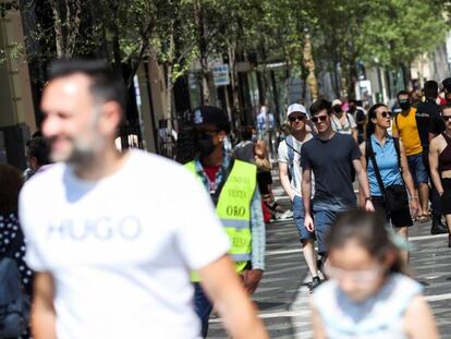 Varias personas pasean con y sin mascarilla, en el centro de Madrid.