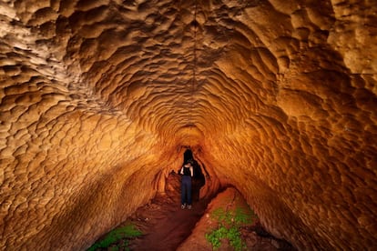 Una turista se asoma a una cueva a orillas del río Manambolo.